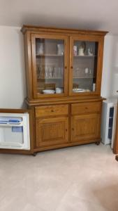 Isola del CantoneAi serri 27的微波炉旁边是一个摆放着餐具的木制橱柜。 更多13张照片