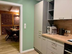 a kitchen with white cabinets and a table in a room at Gemütliche Heidschnucke in Soltau