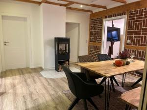 a living room with a wooden table and a fireplace at Gemütliche Heidschnucke in Soltau