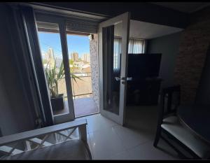 salon z przesuwnymi szklanymi drzwiami z widokiem w obiekcie Depto Comahue Playa Necochea w mieście Necochea