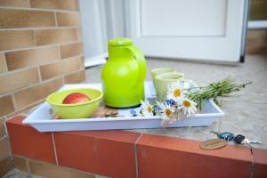 un vassoio con una brocca verde, ciotole e fiori di Ferienhaus In Alt Schadow Mit Grill Und Terrasse a Markische Heide