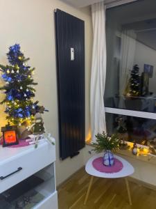 a living room with a christmas tree and a table at Apartament NIEBO Ustroń in Ustroń