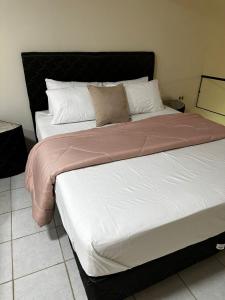 1 cama con cabecero negro en un dormitorio en Hollywood Alojamiento, Apt 3, en Ciudad del Este 2 fotos más