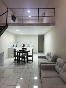 Una sala de estar con sofás y una mesa y una cocina. en Hollywood Alojamiento, Apt 3, en Ciudad del Este