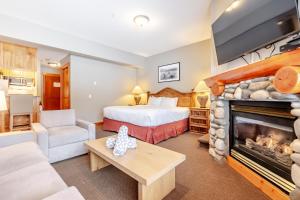 a hotel room with a bed and a fireplace at Lizard Creek Lodge in Fernie