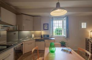 a kitchen with a table with a green vase on it at Gemütliche Ferienwohnung Le Volte in Lastra a Signa +16 photos
