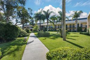 une passerelle devant un bâtiment planté de palmiers dans l'établissement Best Western Plus South Coast Inn, à Santa Barbara