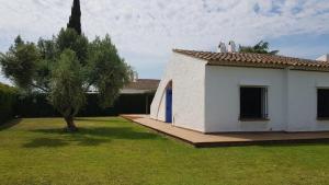 a small white house with a tree in the yard at Acacies 25 in Torroella de Montgrí