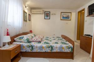 a small bedroom with a bed and a dresser at Fewo Superior in Grebaštica