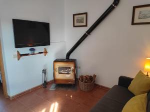 a living room with a wood stove and a tv at Casa la Poveda in Villa del Prado +29 photos