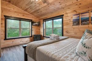 a bedroom with a bed in a log cabin at Smoky Mountain Cabin, Sleeps 12, 2 Kitchens & Hot Tub in Pigeon Forge +31 photos