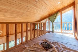 Großes Zimmer mit Holzdecke und Fenstern in der Unterkunft The Clifton chapter sojha in Banjār