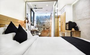 a bedroom with a large white bed with black pillows at One Luxury Suites in Belgrade
