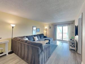 een woonkamer met een grote bank en een tv bij Winds V1 #3B - My Top Paradise in Carolina Beach