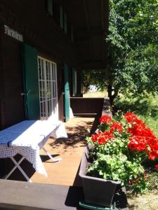 eine Veranda mit einem Tisch und Blumen auf einer Terrasse in der Unterkunft Ferien Cottage Flüehblüemli in Stechelberg + 5 Fotos