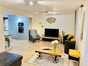 ein Wohnzimmer mit Sofa und Fernseher in der Unterkunft Maison Le V - Proche Disney in Montévrain