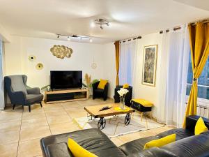ein Wohnzimmer mit Sofa und Fernseher in der Unterkunft Maison Le V - Proche Disney in Montévrain