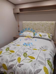 a bed with a white comforter and two pillows at Trekkers Rest, Brigham, Cockermouth, Cumbria in Cockermouth