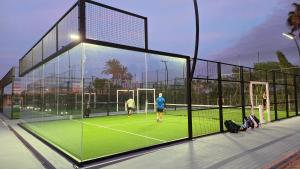 drei Personen spielen Tennis auf einem Tennisplatz in der Unterkunft Apartment with a beautiful view with a terrace in Roda golf & Beach resort in San Javier