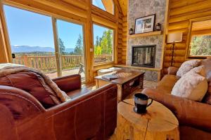 ein Wohnzimmer mit Couch und Kamin in der Unterkunft New Log Home, Hot Tub For 8, Views! in Tabernash + 41 Fotos