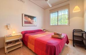 ein Schlafzimmer mit einem Bett mit einer roten Decke und einem Stuhl in der Unterkunft Lovely Home In Pilar De La Horadada With Wifi in El Mojón + 26 Fotos