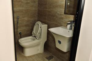 a bathroom with a toilet and a sink at Four Stays Khobar in Al Khobar