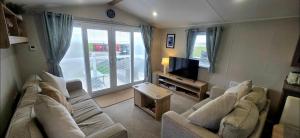 a living room with two couches and a television at Our Sea View - Heysham in Heysham