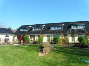 a large yellow house with a green yard at Ferienhaus In Neuenkirchen Mit Terrasse in Neuenkirchen