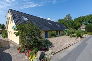 a yellow house with a black roof and a yard at Ferienhaus In Neuenkirchen Mit Terrasse in Neuenkirchen