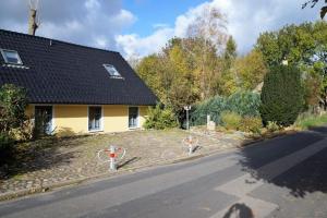 a yellow house with a road next to a house at Ferienhaus In Neuenkirchen Mit Terrasse in Neuenkirchen