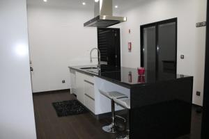a kitchen with a black counter and a sink at Vivenda Paraíso in Candelária
