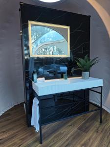 Un baño con un lavabo azul y un espejo. en Cromore Retreat, en Portstewart