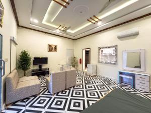 a living room with couches and a tv and a television at The Orchard Haven in Islamabad +6 photos