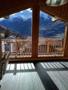 een kamer met een groot raam met uitzicht op de bergen bij Half duplex chalet, facing south with Mont Pourri in Sainte-Foy-Tarentaise
