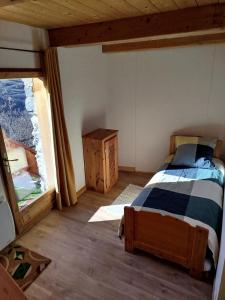 een slaapkamer met een bed en een raam bij Half duplex chalet, facing south with Mont Pourri in Sainte-Foy-Tarentaise