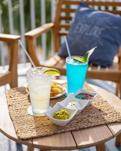 Compass Hotel Beaufort by Margaritaville في Beaufort: طاولة مع صينية طعام ومشروبين
