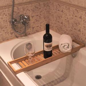 eine Flasche Wein und ein Glas in der Badewanne in der Unterkunft Ski view suite Emerald Bansko in Bansko + 29 Fotos