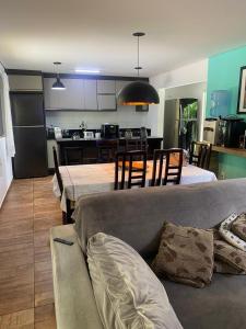 ein Wohnzimmer mit Sofa und eine Küche in der Unterkunft Encantadora Casa Campeche in Florianópolis