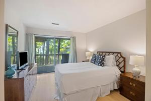 a white bedroom with a bed and a television at IC50: 50 Inlet Cove in Kiawah Island +55 photos