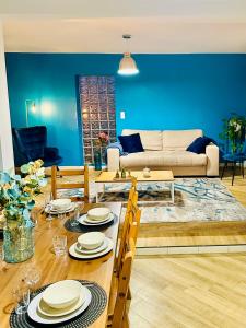 un salon avec une table et un canapé dans l'établissement Maison le B - Disneyland Paris - Parking - Wifi, à Bussy-Saint-Georges