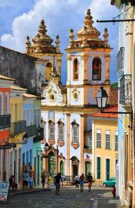 un grand bâtiment avec des gens qui marchent devant dans l'établissement Pelourinho House Experience, à Salvador