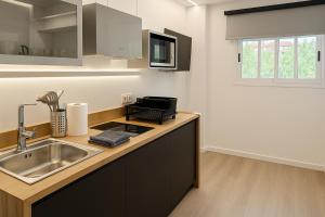 a kitchen with a sink and a counter top at Prime Suites Valencia in Valencia