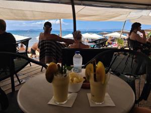 a table with two drinks and a bowl of food at Arkoudi Bella Vista in Arkoudi