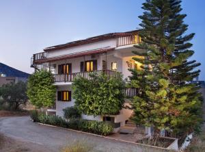 een gebouw met een boom ervoor bij Monemvasia Green Apartments in Monemvasia