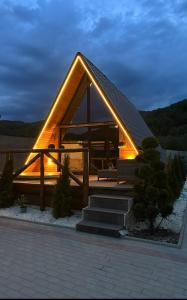 a house with a lit up roof with stairs at Forest Property in Hăghiac