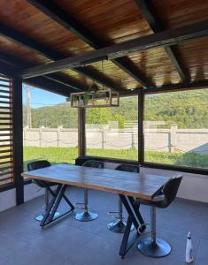 a large wooden table with chairs in front of a window at Forest Property in Hăghiac