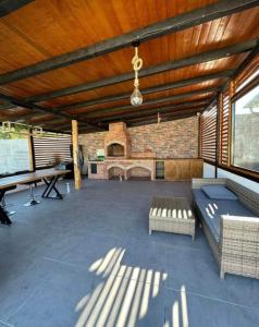 a large outdoor patio with a ping pong table and a brick fireplace at Forest Property in Hăghiac +3 photos