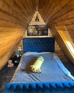 a bedroom with a blue bed in a attic at Forest Property in Hăghiac