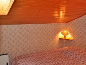 ein Schlafzimmer mit einem Bett mit einer Lampe an der Wand in der Unterkunft 3 pièces près du centre, animaux admis, parking - FR-1-692-7 in La Chapelle-dʼAbondance