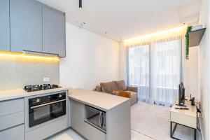 a kitchen and living room with a counter and a desk at Apto em prédio com Piscina, Região Nobre - TEM0205 in Curitiba